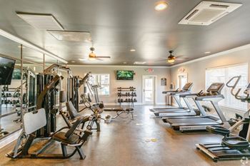a spacious fitness room with cardio equipment and a flat screen tv at The Venue at 109 Apartments , Lebanon, TN, 37090