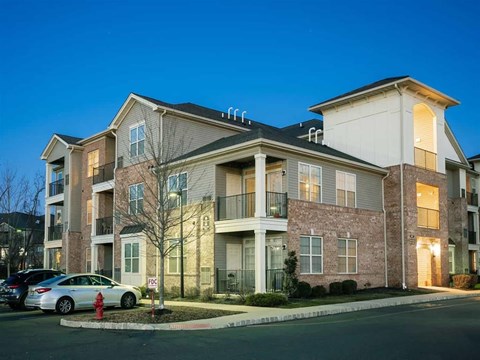 A modern apartment building with a parking lot in front.