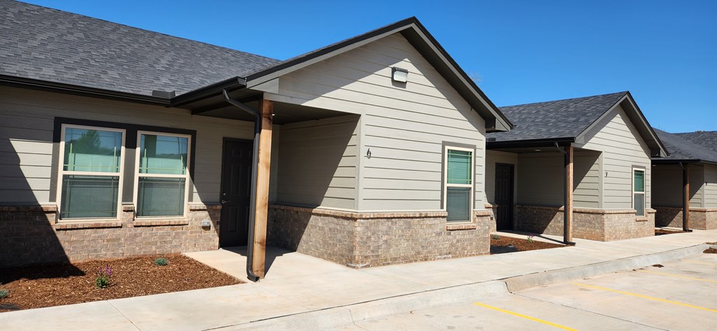 A small building with a grey roof and a yellow line in front.