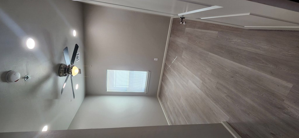 A room with a ceiling fan and a window.