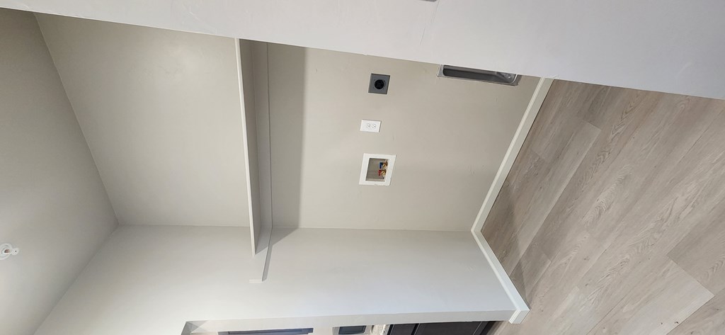 A white kitchen with a wooden floor and a white ceiling.