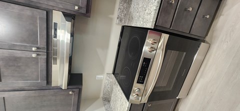 A modern kitchen with a built-in oven and microwave.