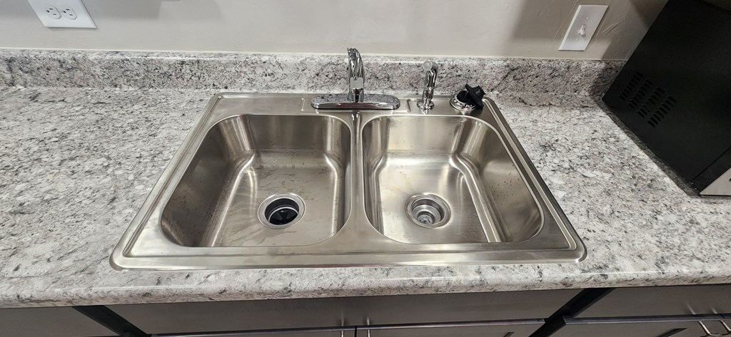 A double sink in a granite countertop.