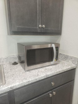 A silver microwave oven sitting on a counter.