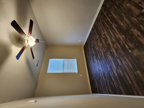 A ceiling fan in a room with a window.