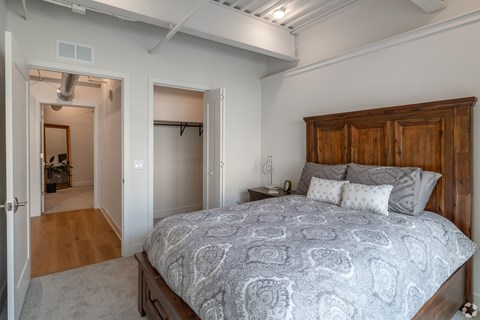 A bedroom with a large bed and a wooden headboard.