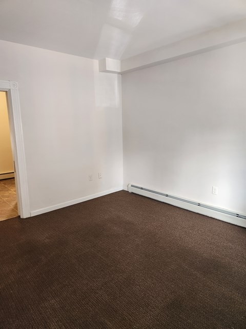 A room with brown carpet and white walls.