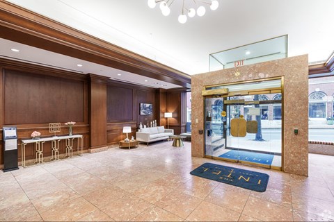 A hotel lobby with a blue carpet and a glass door.