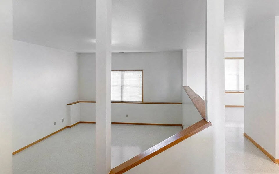 an empty room with white walls and a window
