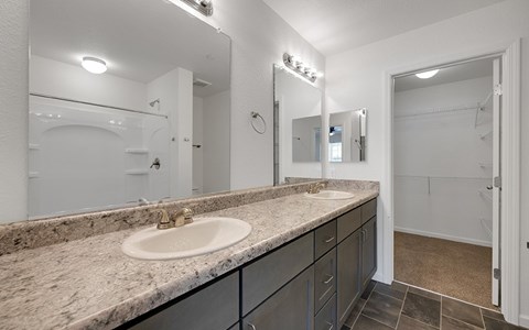 A bathroom with a sink, mirror, and lighting fixture.