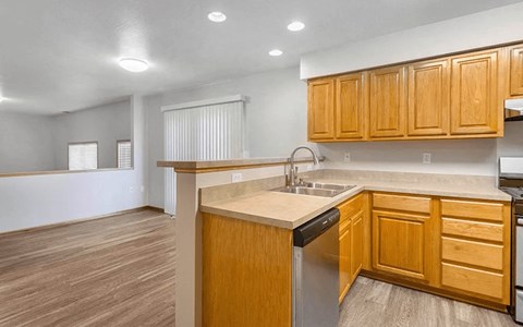 an empty kitchen with wooden cabinets and a sink
