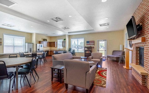 a common room with chairs and tables and a fireplace