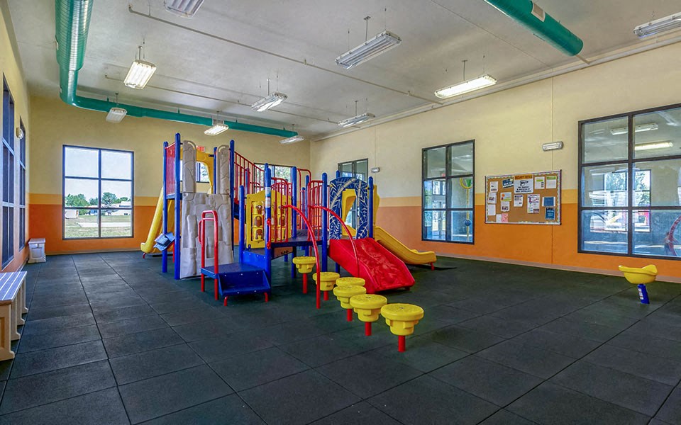 a room with a playground and colorful stools