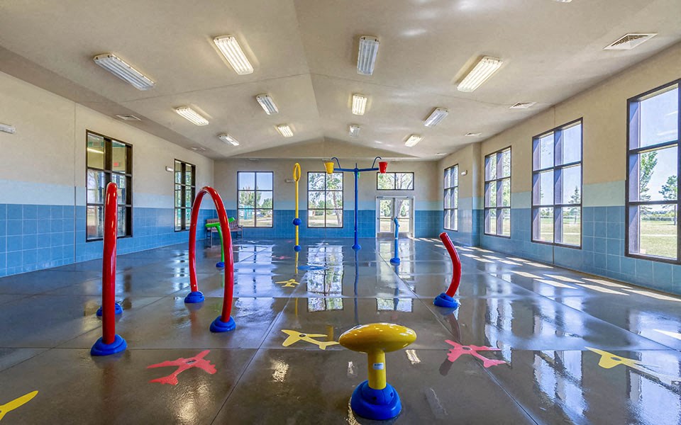 a childrens playroom in a building with toys on the floor