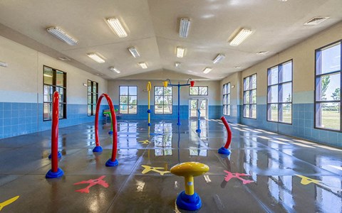 a childrens playroom in a building with toys on the floor