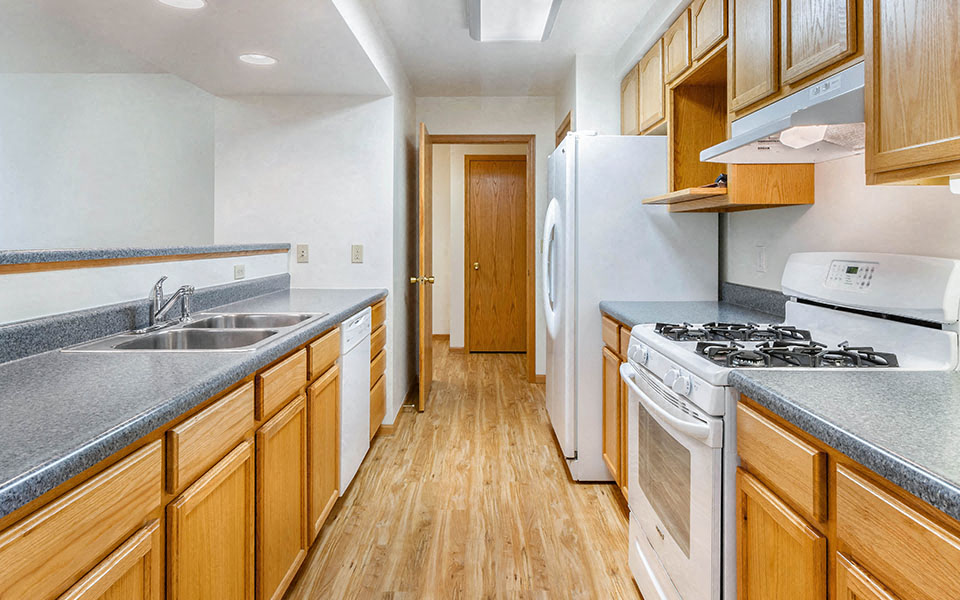 a kitchen with wooden cabinets and white appliances