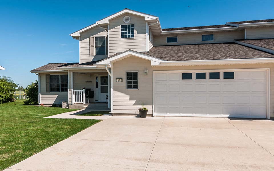 a white house with a driveway and a garage door
