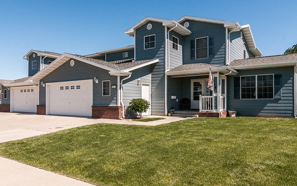 a blue house with a lawn in front of it