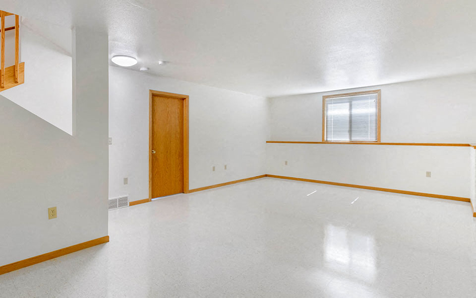 the living room of an empty house with a wooden door