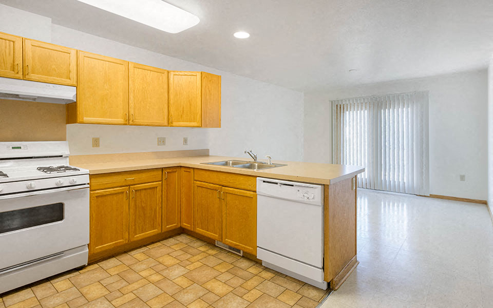 a kitchen with white appliances and wooden cabinets
