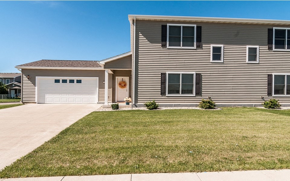 a house with a white garage door and a lawn
