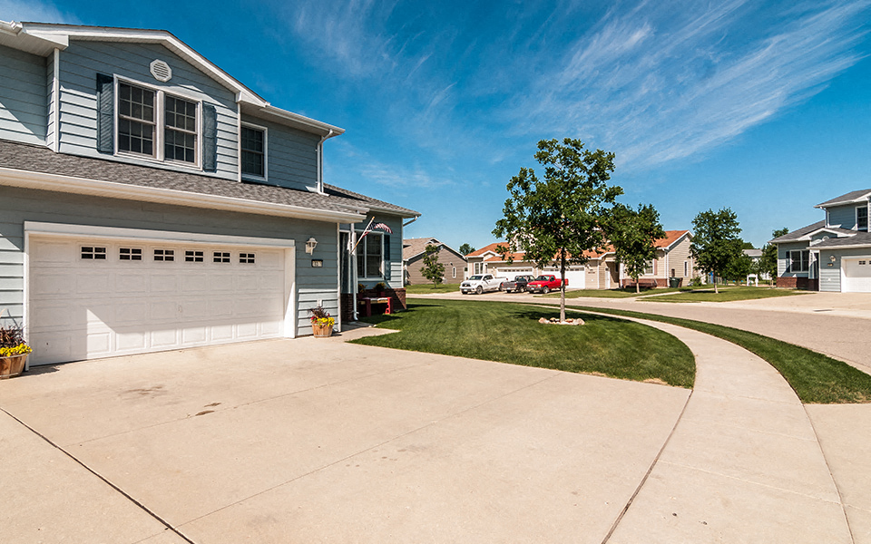 a driveway in front of a house with a white garage door