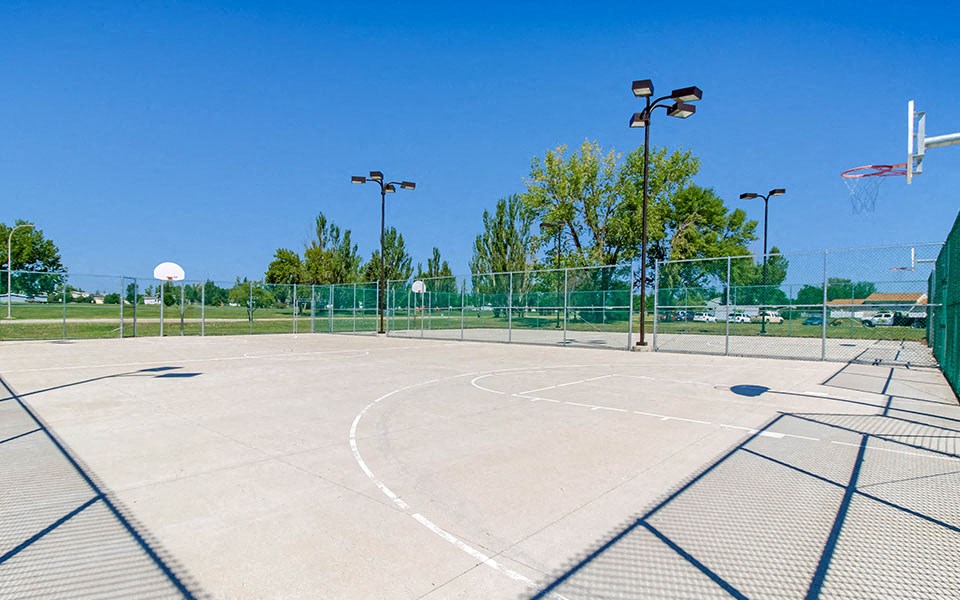 a basketball court at a park on a clear day