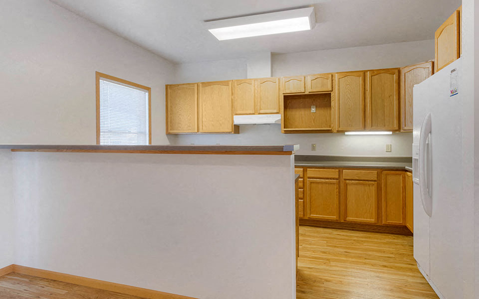 a kitchen with wooden cabinets and a white counter top
