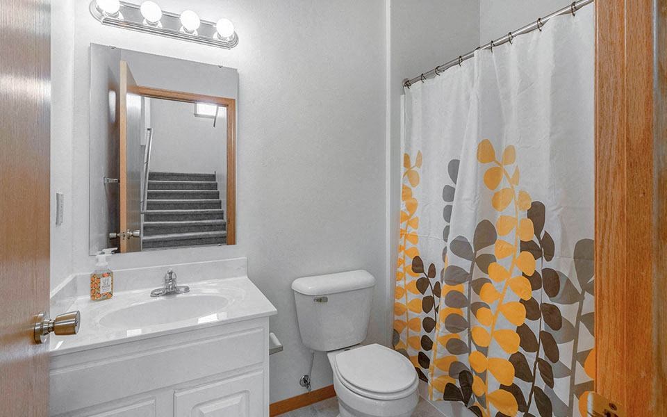 a bathroom with a shower curtain and a toilet and a sink