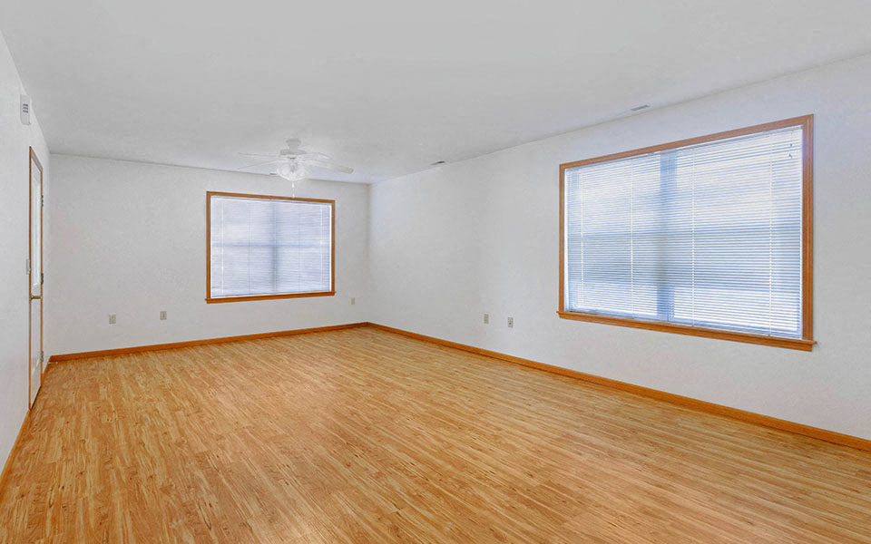 an empty room with wood floors and a window