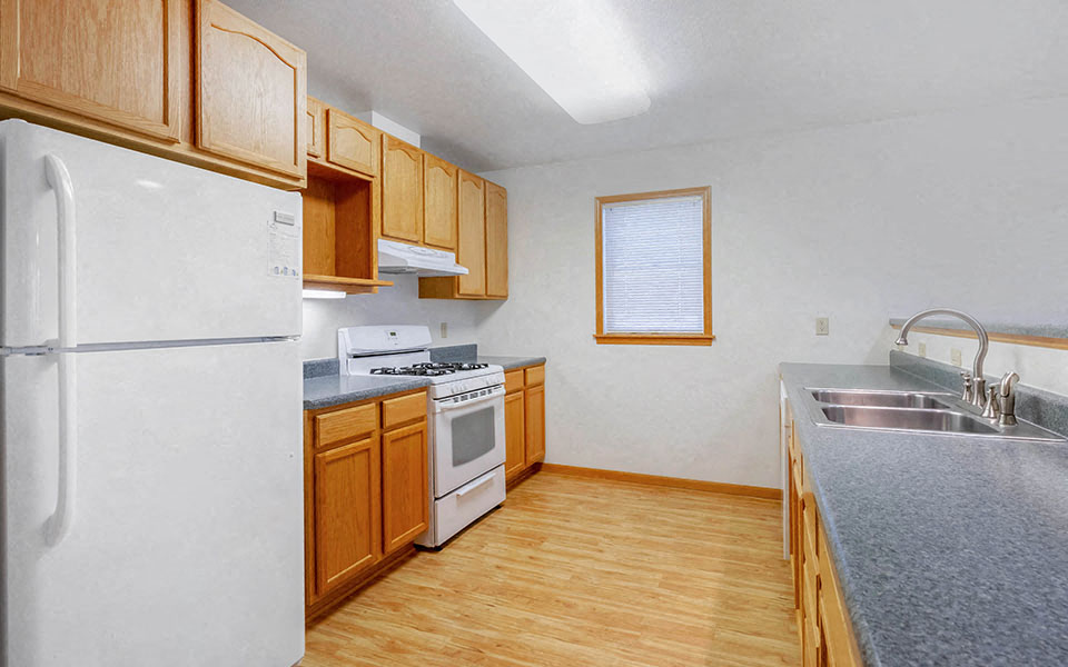 a kitchen with a stove refrigerator and a sink