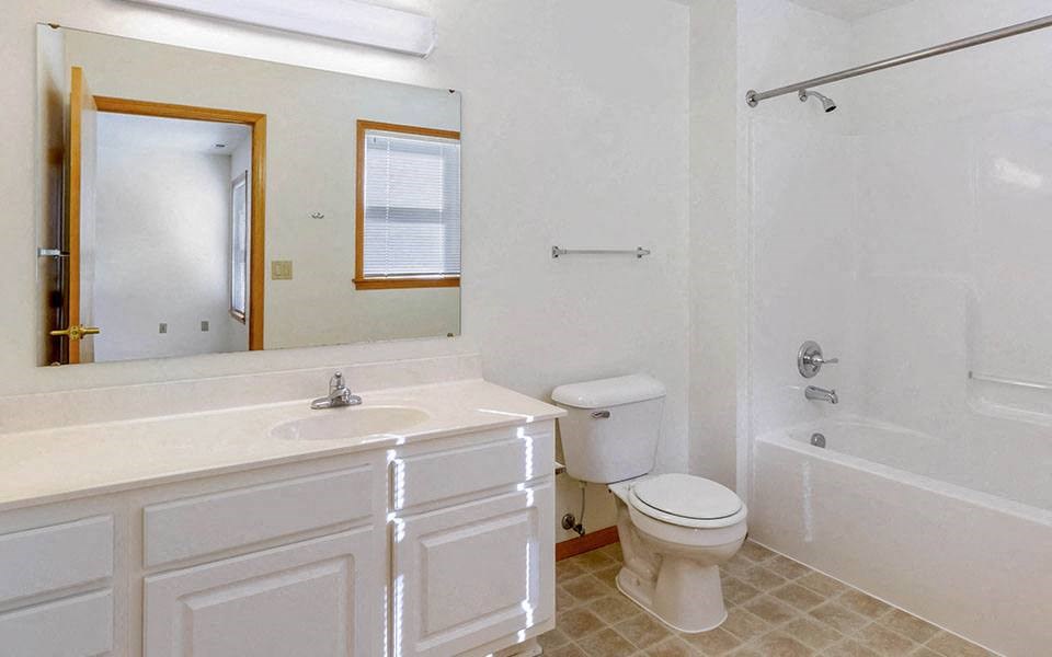 a white bathroom with a toilet and a sink