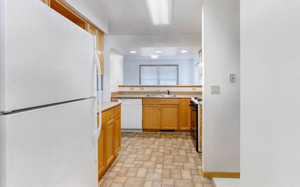 a kitchen with white appliances and wooden cabinets
