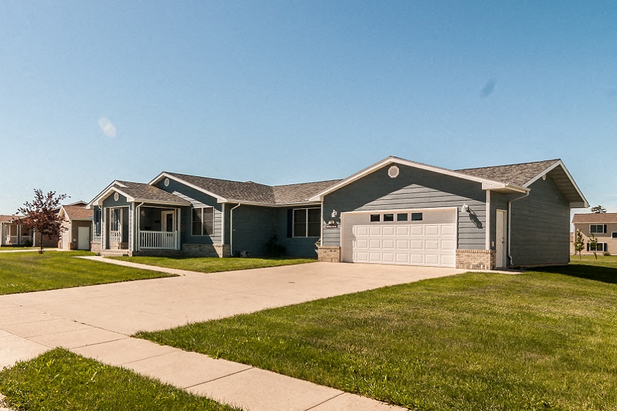 a blue house with a driveway and a garage door