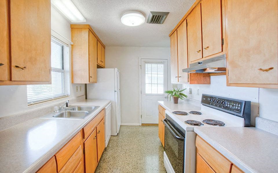 a kitchen with a stove top oven and a sink