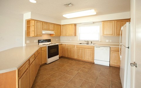 a kitchen with wooden cabinets and white appliances