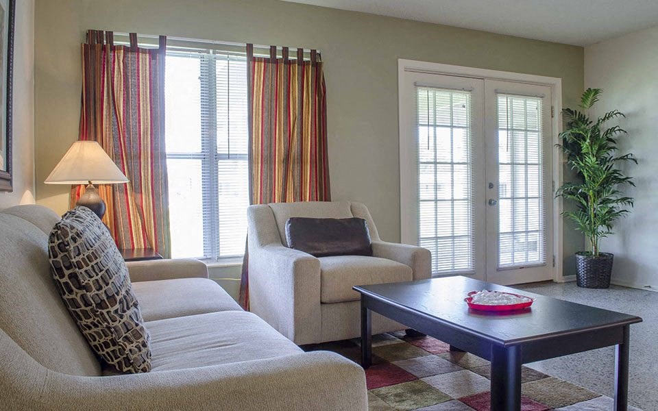 a living room with a couch and chairs and a coffee table