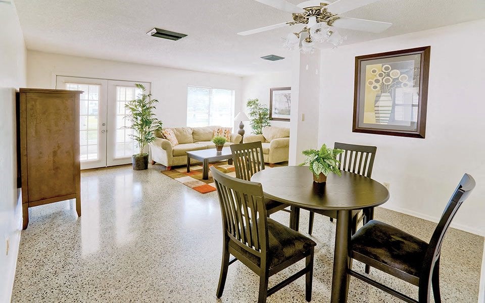a living room and dining room with a table and chairs