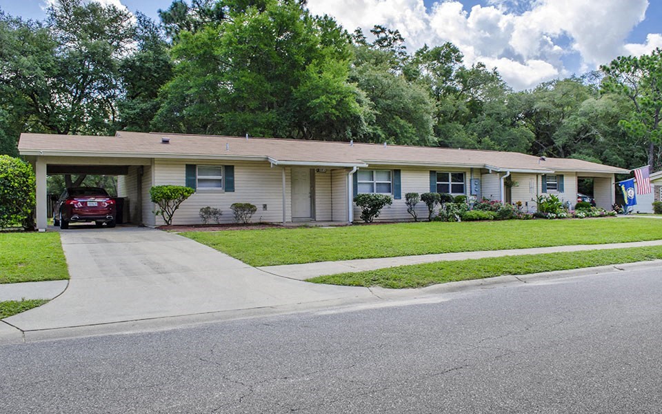 a white house with a red car parked in the driveway