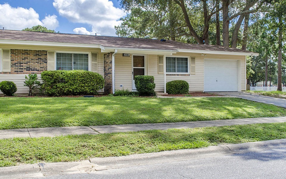 a white house with a lawn and trees