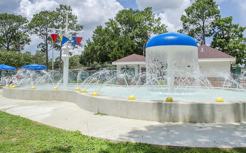 a water fountain in a park with a blue and white dome