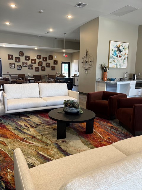 A living room with a white couch, a coffee table, and a rug.
