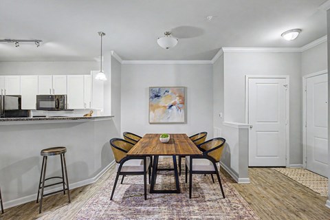 A dining room with a wooden table and chairs.