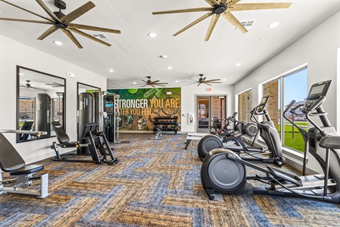 A gym with a variety of equipment including treadmills, stationary bikes, and weight machines.