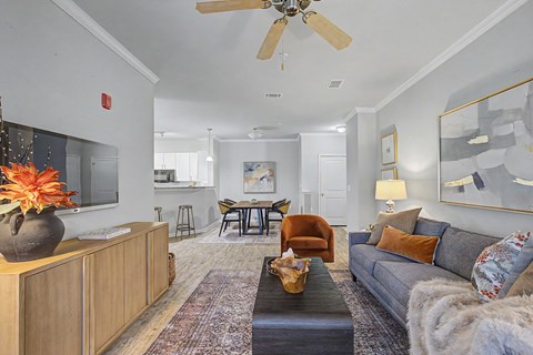 A living room with a grey couch and a wooden cabinet.