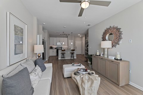 A modern living room with a white couch and a wooden floor.