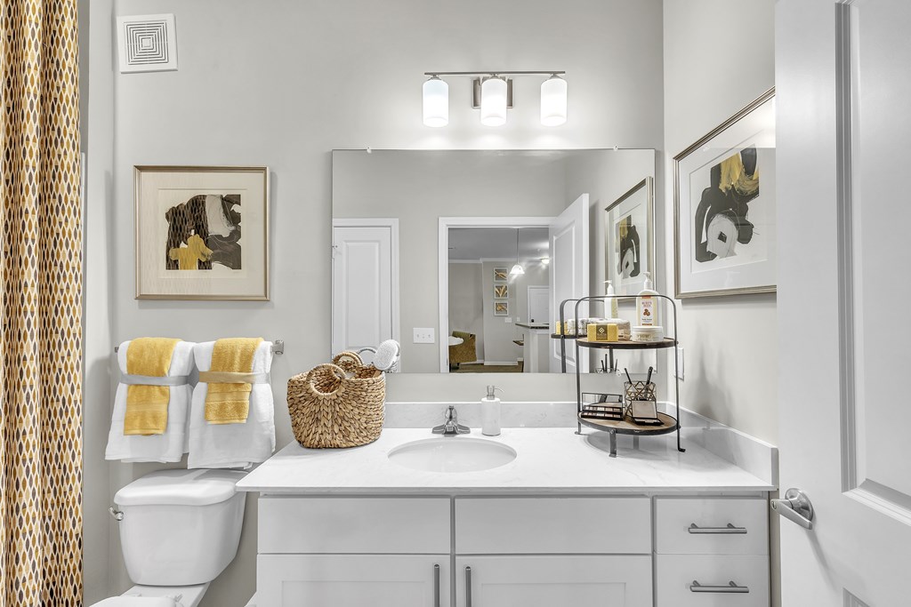 Bathroom with a white toilet, sink, and a mirror at Sterling Creek at Richmond Hill, Richmond Hill, GA, 31324