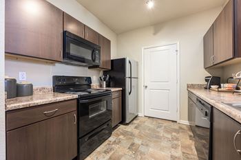 A kitchen with a black refrigerator and stove.