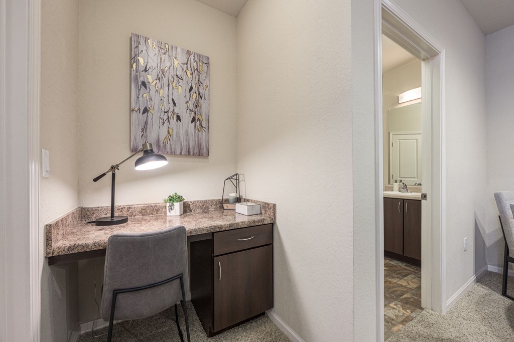 A room with a desk and chair in it.