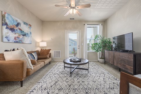 A living room with a brown couch, a coffee table, and a painting on the wall.